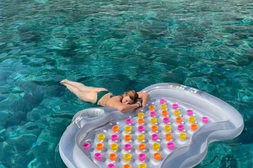 A person floating on a pool float with a heart-shaped inflatable raft. 5