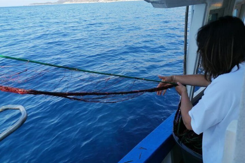 A person on a boat holding a fishing net. 3