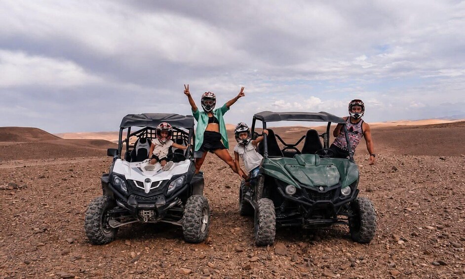 Four people on ATVs in a desert landscape. 2