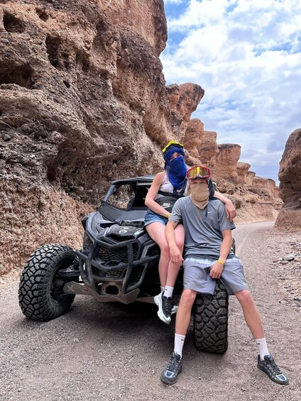 Two people on a dune buggy in a rocky canyon. 4