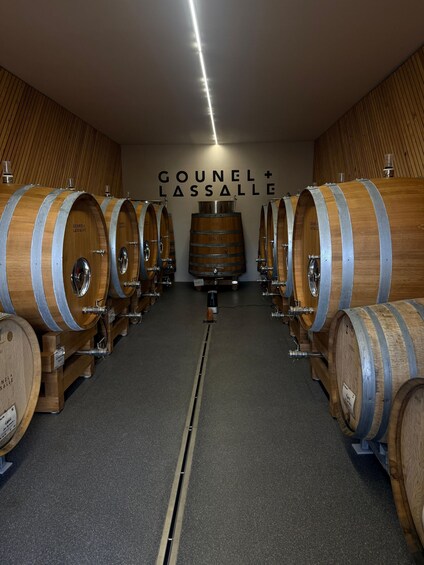 A wine cellar with wooden barrels and a sign reading 'Gounel + Lassalle.' 4
