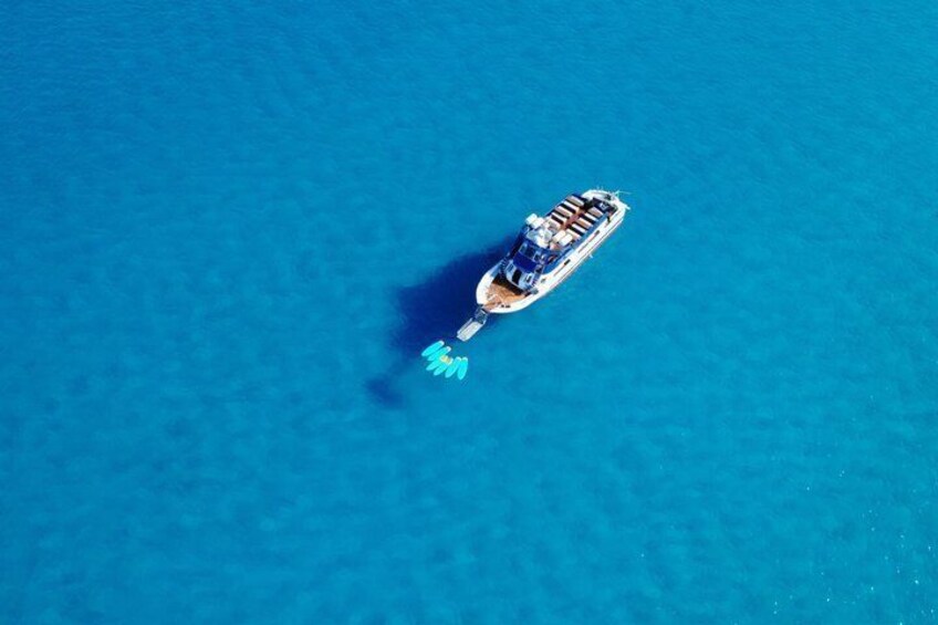 A cruise ship with a blue hull and a white superstructure, floating on a clear blue sea. 2