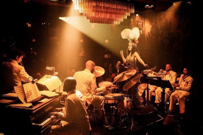 Un groupe de jazz se produit sur scène, éclairé par un projecteur. 4
