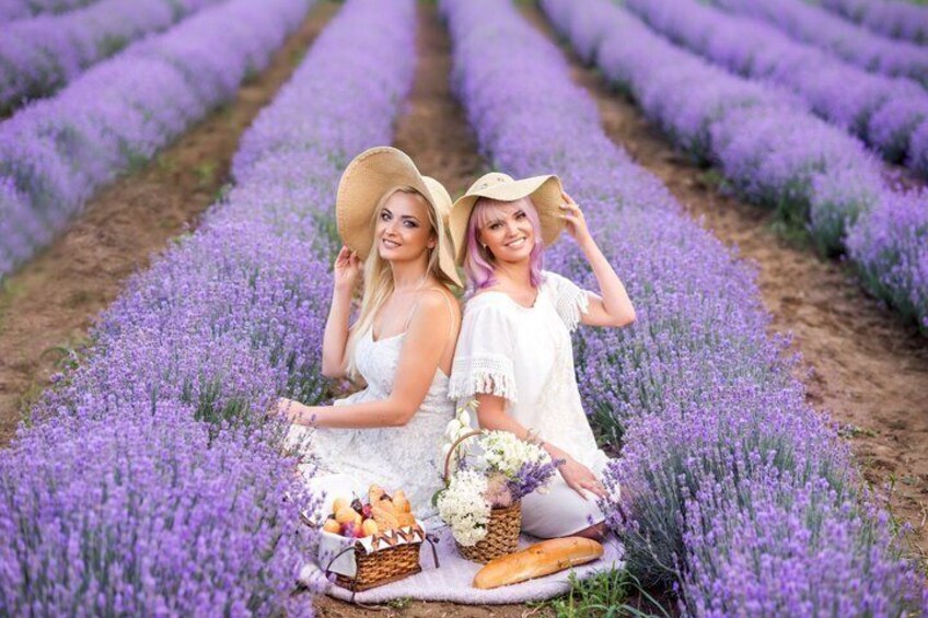 Two people in a lavender field with baskets of flowers and bread. 4