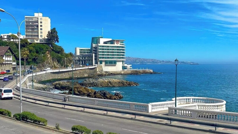 A coastal road with a bridge, buildings, and a clear blue sky. 4