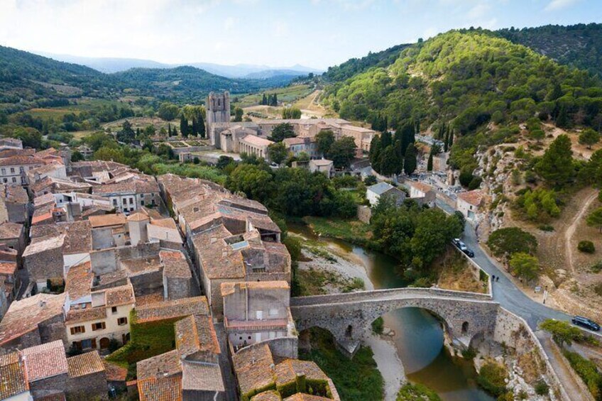 A historic town with a river, a stone bridge, and a church on a hill. 3