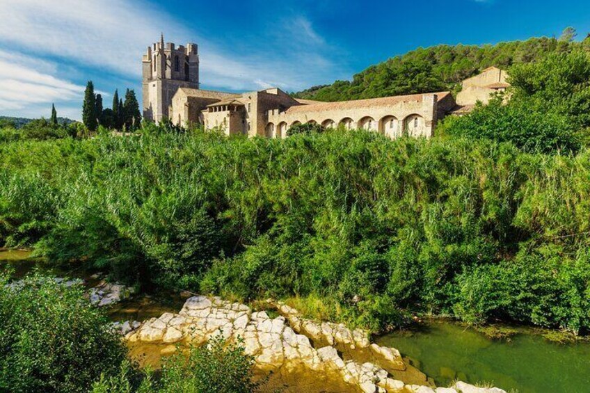 A castle with a tower, surrounded by lush greenery and a river. 5