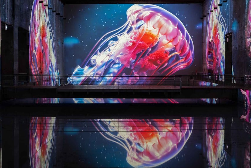 A large, colorful digital display of a jellyfish in a dark, industrial setting. 5
