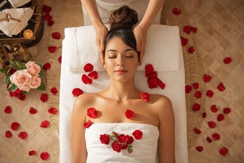 Iemand ontvangt een massage, verspreid met rozenblaadjes. 1