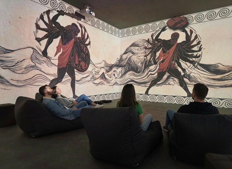 A mural with figures in dynamic poses, a decorative border, and people sitting on bean bags. 5