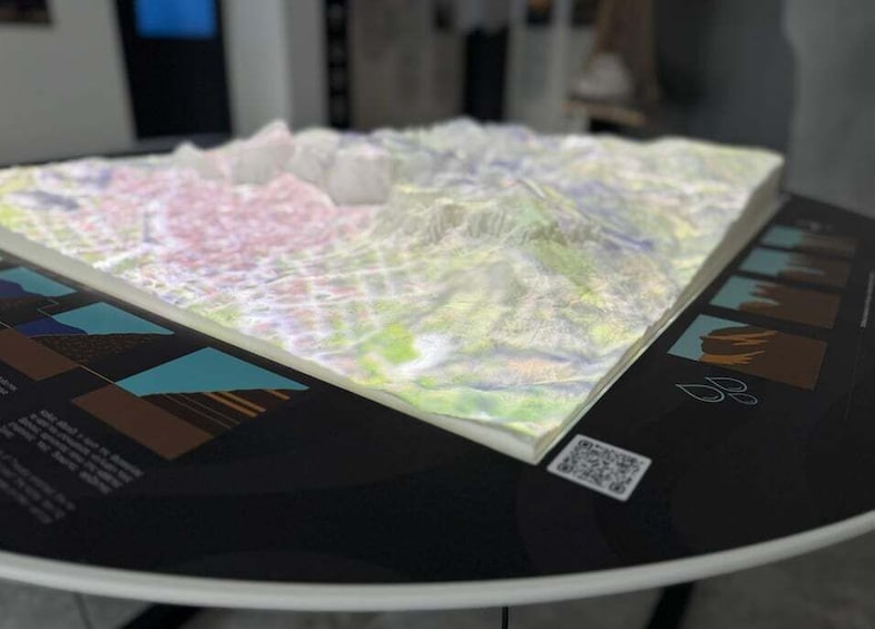 A table with a colorful, textured map and a QR code. 2