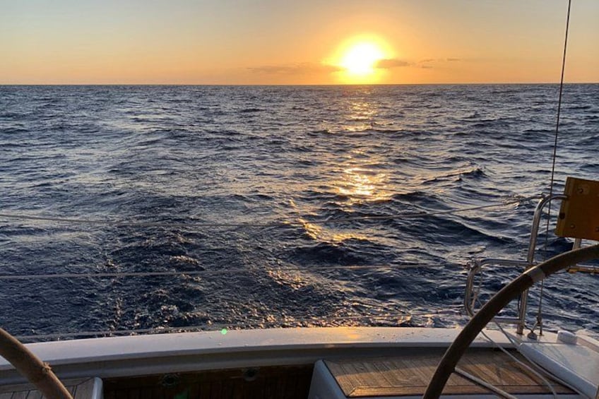 A boat on the ocean with the sun setting in the background. 5