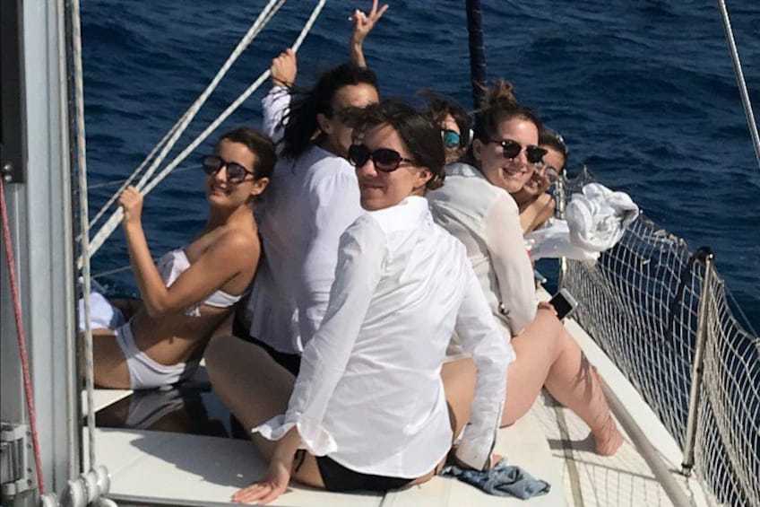 A group of people on a boat with a blue ocean in the background. 1