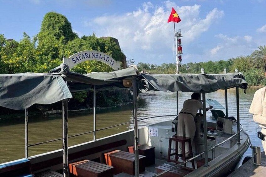 Ein Boot mit einer Markise, einer vietnamesischen Flagge und einem Schild mit der Aufschrift 'SAFARINHA-TD 12'. 3