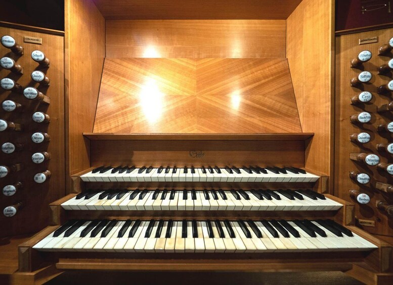 A grand organ with multiple keyboards and a wooden interior. 5
