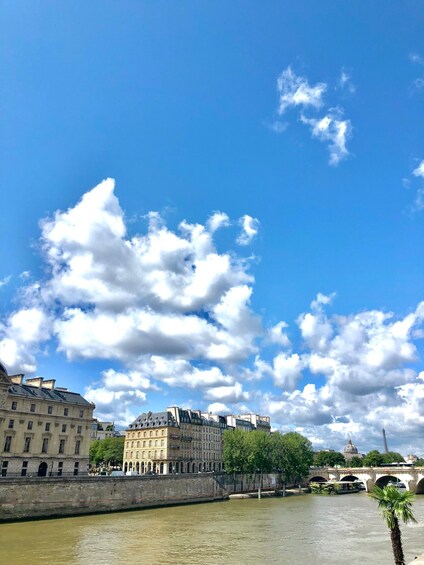 A river with buildings and a bridge, under a partly cloudy sky. 1