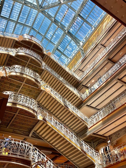 A multi-level atrium with ornate iron railings and a glass ceiling. 3