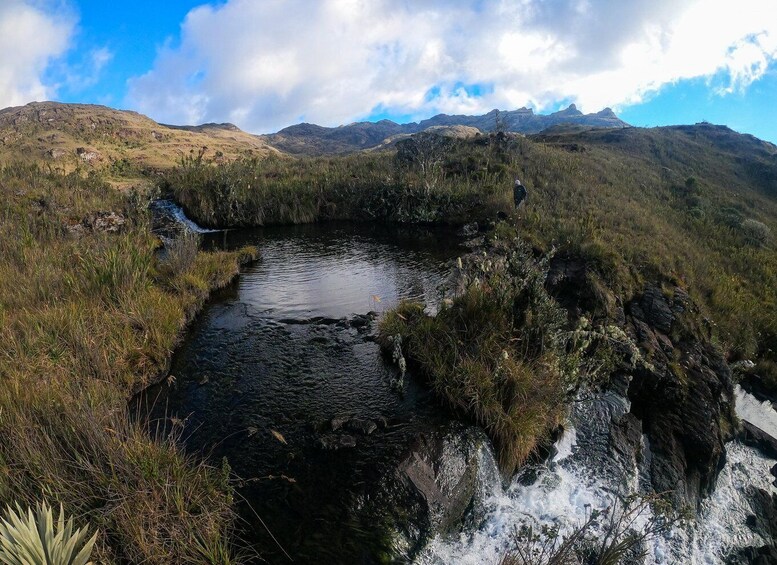 A river flowing through a mountainous landscape with rocky terrain and sparse vegetation. 5