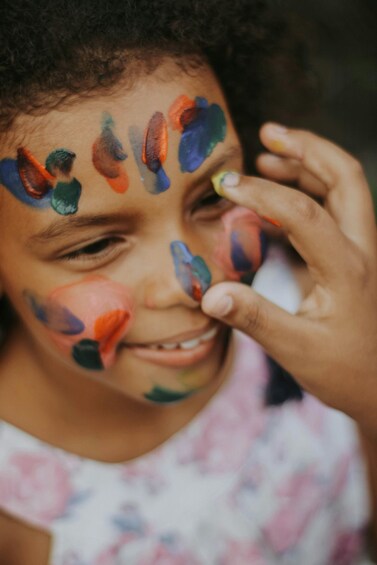 A person with colorful paint on their face. 3