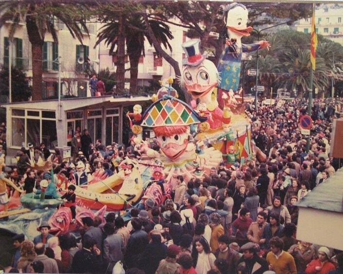A crowded street parade with large, colorful floats and a crowd of people. 5