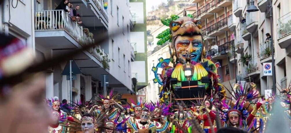 A colorful parade with elaborate costumes and a large, ornate float. 1