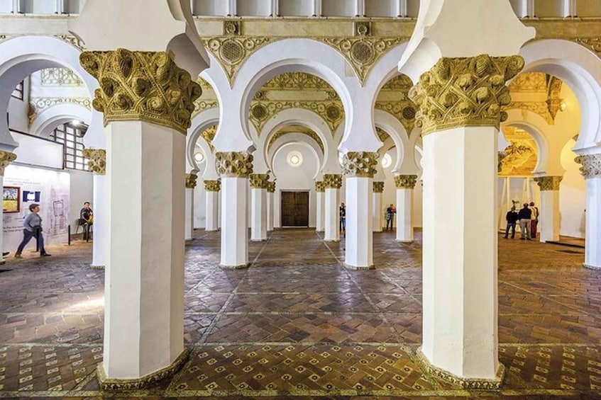 A grand hall with ornate columns and a patterned floor. 2