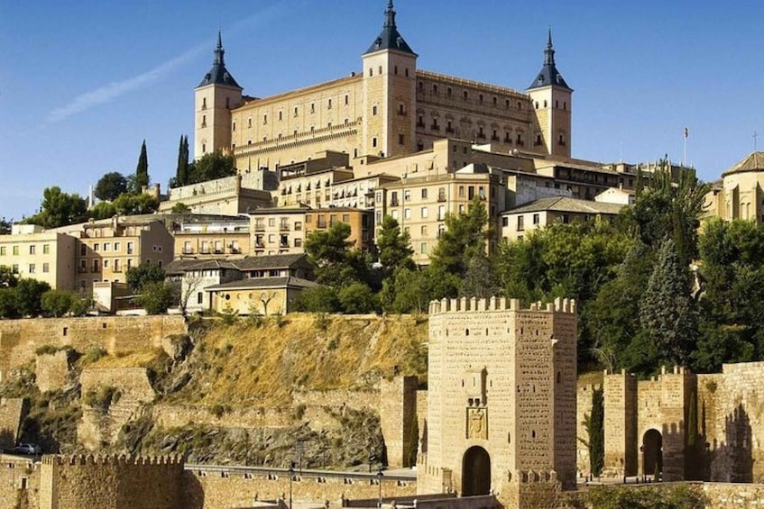 A historic castle with multiple towers, a fortified wall, and a surrounding urban area. 5