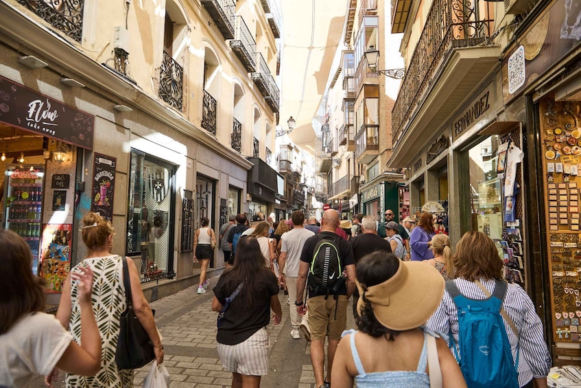 A crowded street with people walking and shops on either side. 4