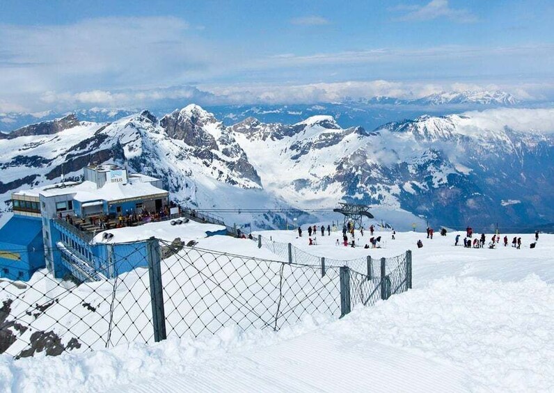 A snow-covered mountain with a ski lift and a building labeled 'TITLIS' in the foreground. 1