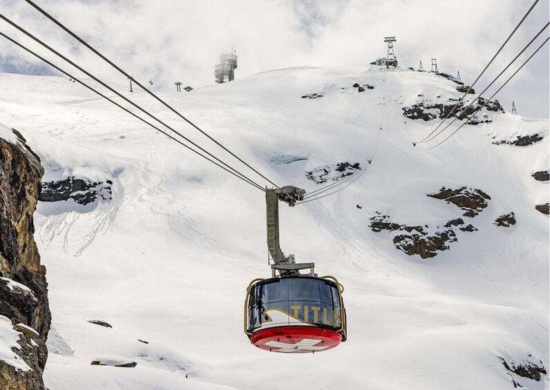 A cable car ascending a snowy mountain slope. 2