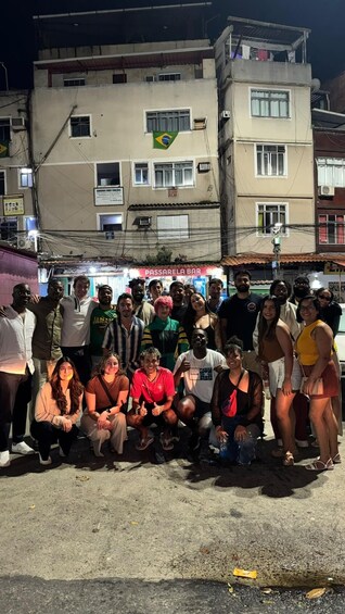 A group of people posing in front of a bar at night. 4