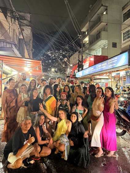 A group of people gathered on a street at night. 1
