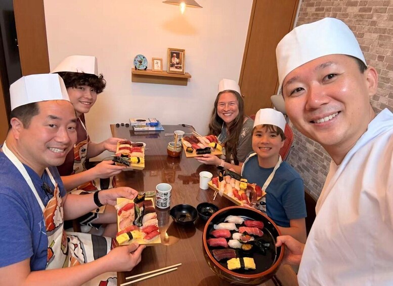 A group of people holding plates of sushi at a restaurant. 2