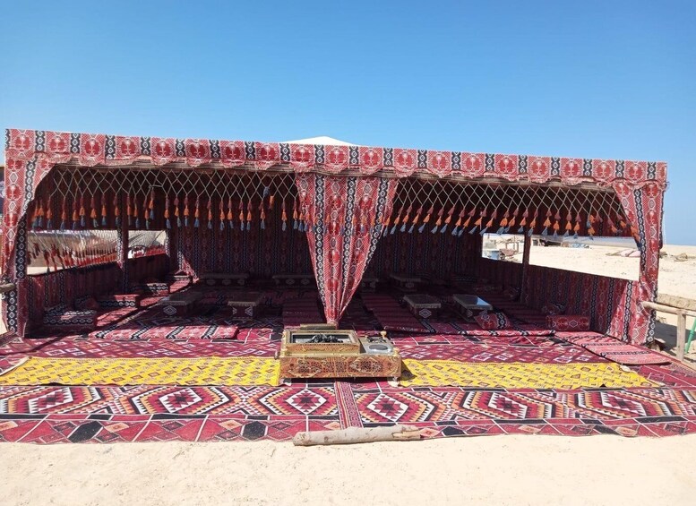 A traditional tent with intricate patterns and a wooden bench in the center. 5