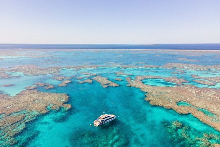 A boat on a coral reef with clear turquoise waters. 1