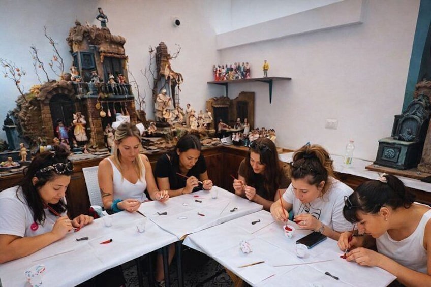 A group of people engaged in a craft activity at a table with various crafting materials. 1