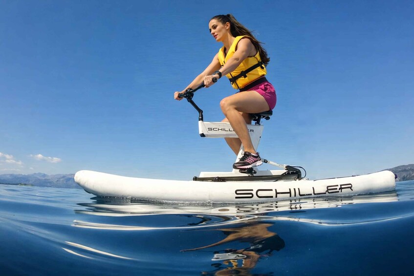 A person riding a white watercraft with 'SCHILLER' branding on it. 1