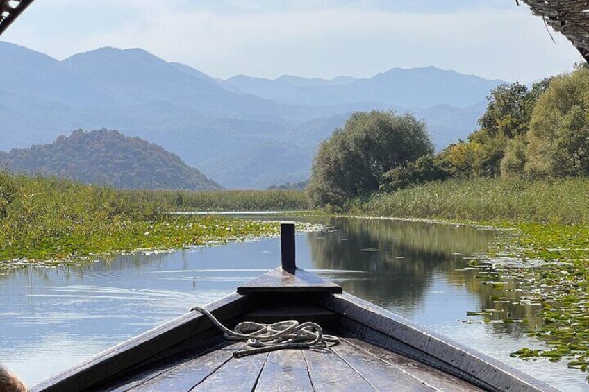 Una barca di legno su acque calme, con montagne sullo sfondo. 1