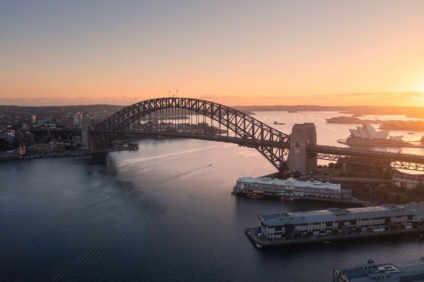 A bridge over water with buildings and the Sydney Opera House in the background. 5