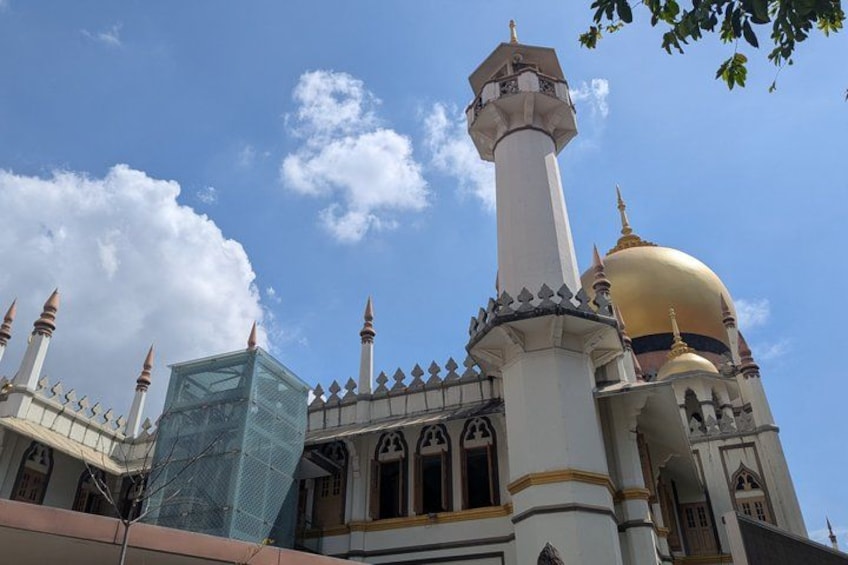 Eine Moschee mit einer goldenen Kuppel, Minaretten und einem hohen Minarett. 3