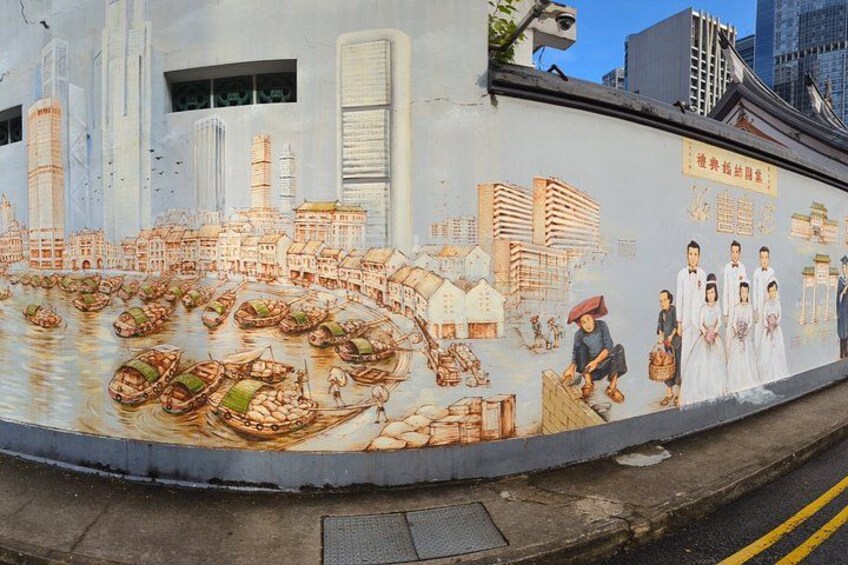 A mural depicting traditional boats and buildings, with modern skyscrapers in the background. 2
