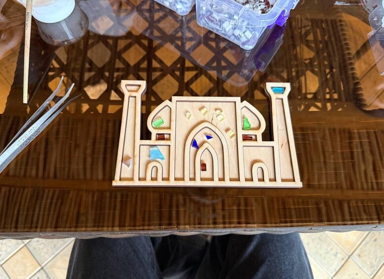A wooden puzzle with a mosque design, a plastic container, and a glass table. 5