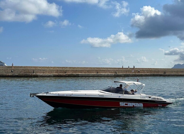 A speedboat named 'ESCAPE' on the water with a clear sky and a stone pier in the background. 3