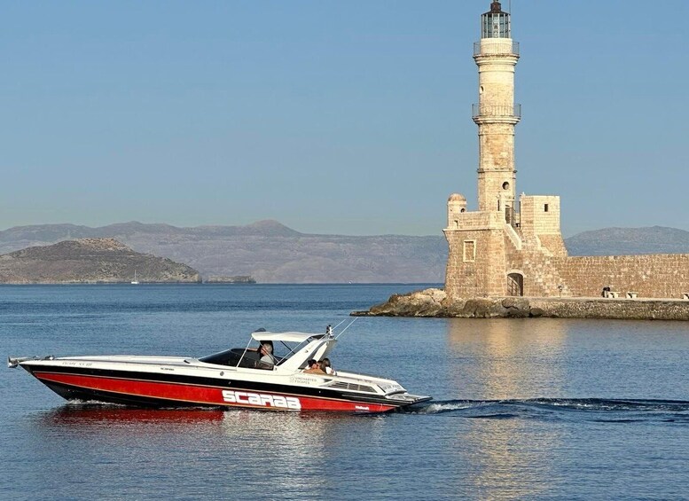A speedboat named 'SCARAB' on the water near a lighthouse and rocky coastline. 4