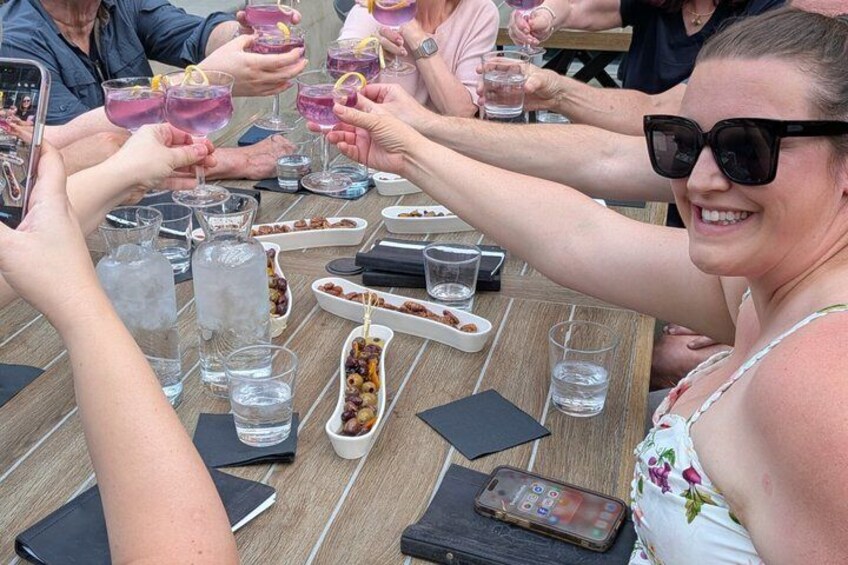 A group of people toasting with drinks at a wooden table. 2