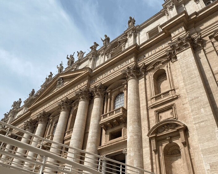 A grand neoclassical building with columns, statues, and inscriptions. 2