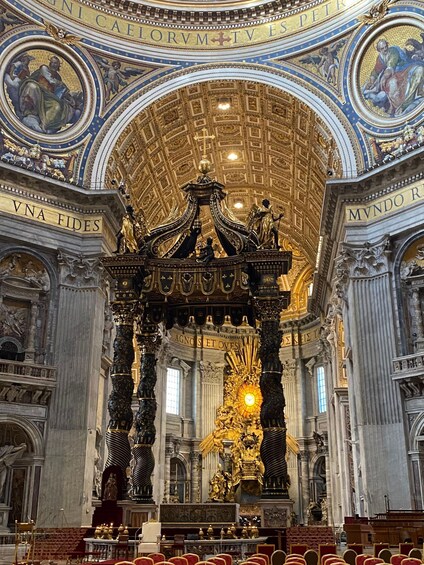 An ornate church interior with a golden altar, columns, and detailed frescoes. 1