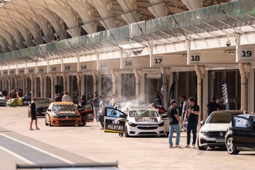 A car racing event with multiple race cars and spectators. 3