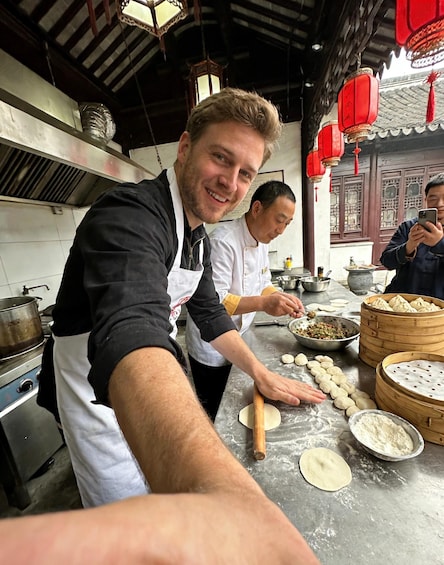Chefs preparing dumplings in a traditional kitchen with wooden utensils and red lanterns. 1