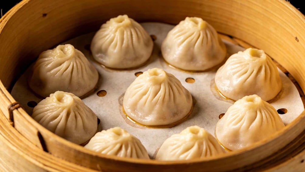 A bamboo steamer with several dumplings. 2
